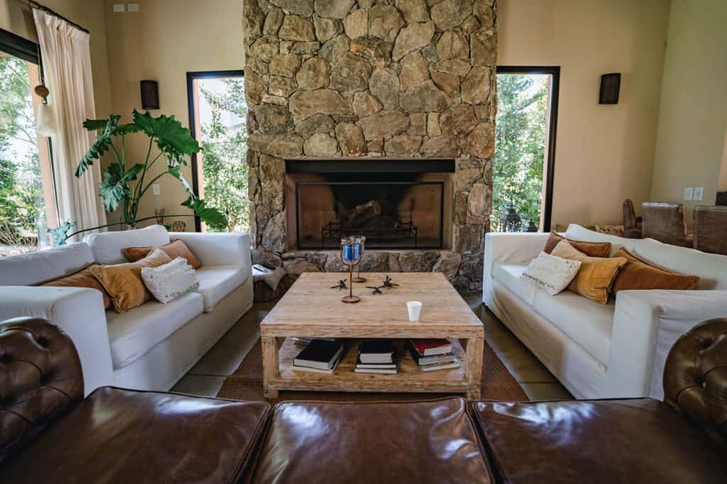 Living room with decorative rock paneling fireplace and white couches