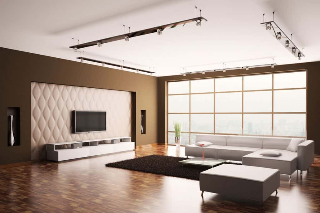 Living room with huge window at right and TV set mounted at walls as centerpiece