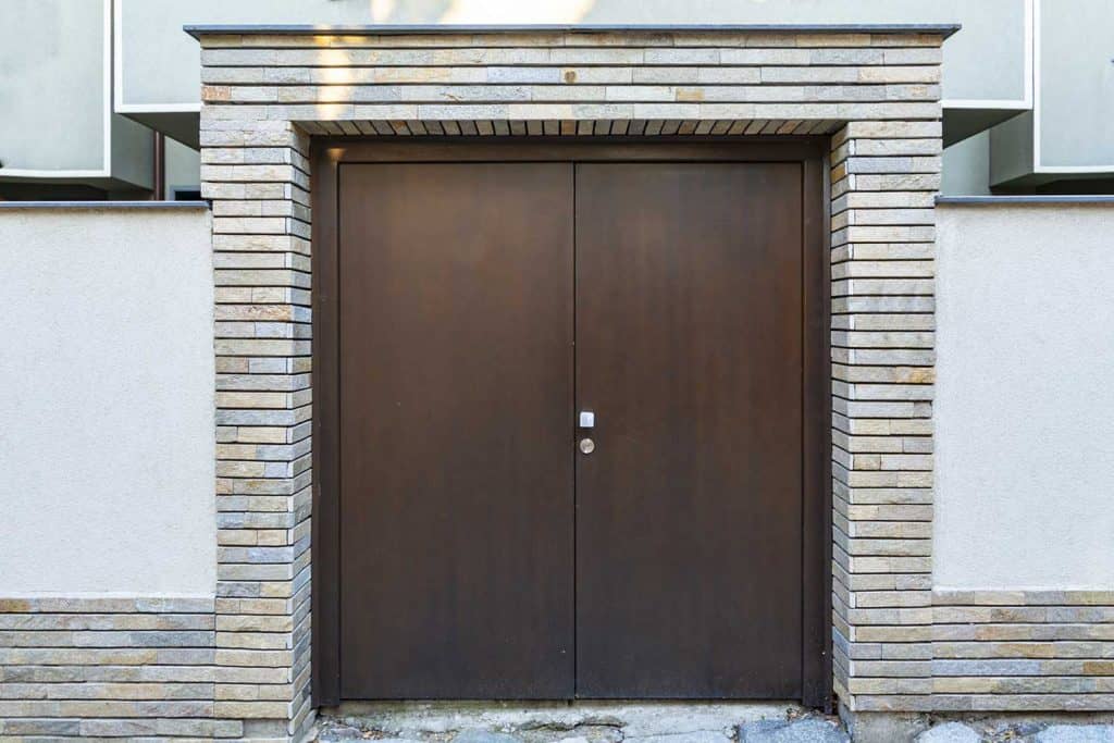 Modern front double door surrounded by brick walls
