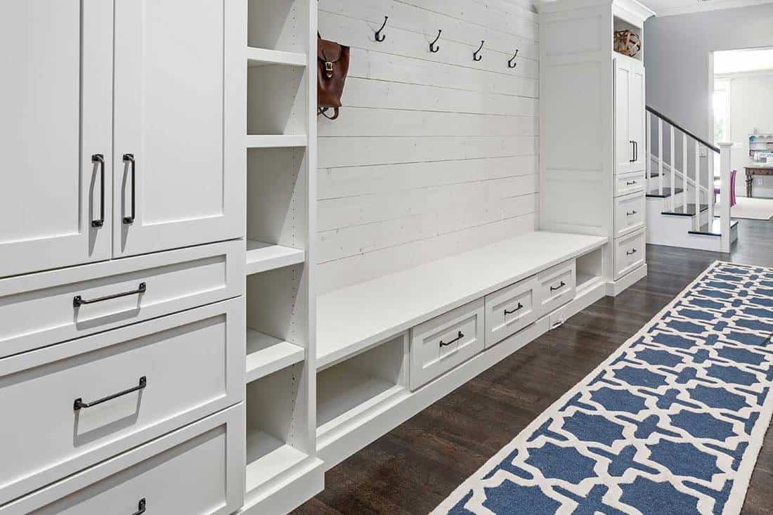 Mud room of a white modern house with hardwood floor and white wooden cabinets, What Is The Mudroom In A House?