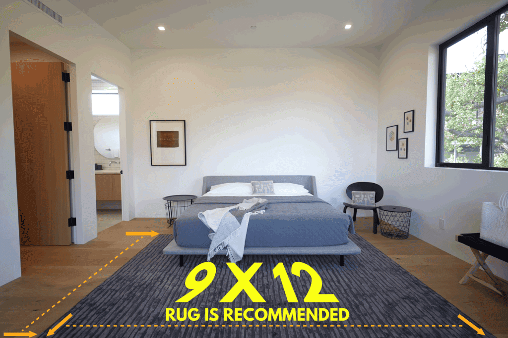 Interior of a white walled bedroom with wooden flooring matched with a blue rug and a blue king sized bed, What Size Rug To Place Under A King Bed?
