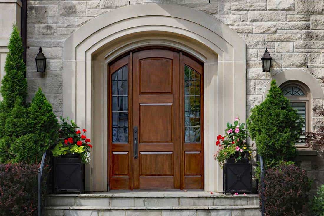 elegant front door of stone house with flagstone steps, How Much Does A Front Door Cost?