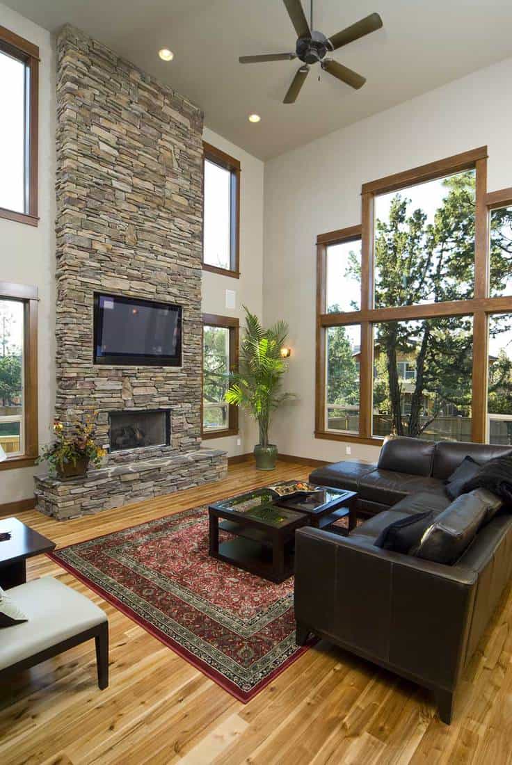 Living room with brown leather sofa, fireplace and brick wall