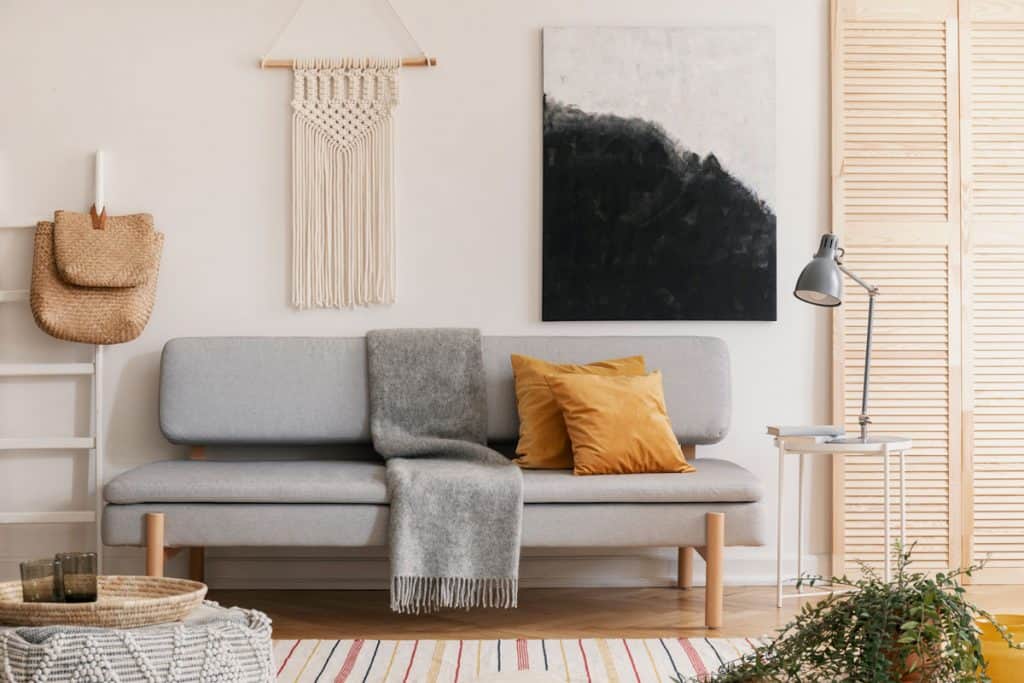 Living room with grey couch, decorative items and abstract painting on wall