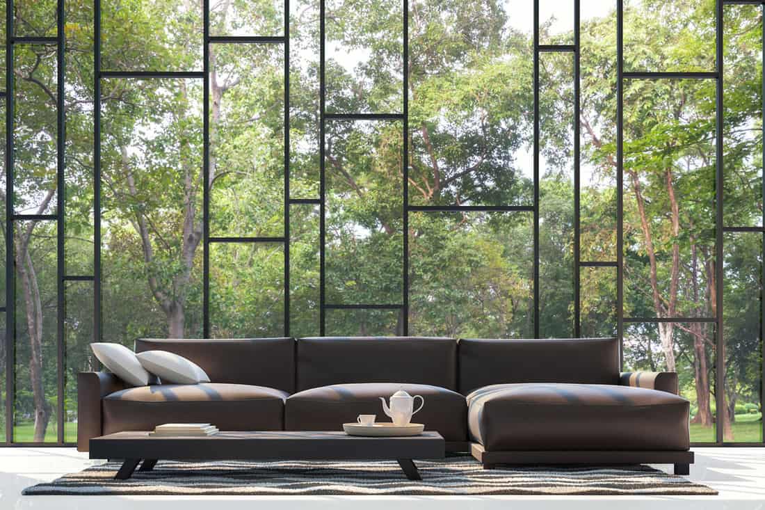 Huge couch near huge window and trees on the background, 13 Fantastic Couches for Tall People