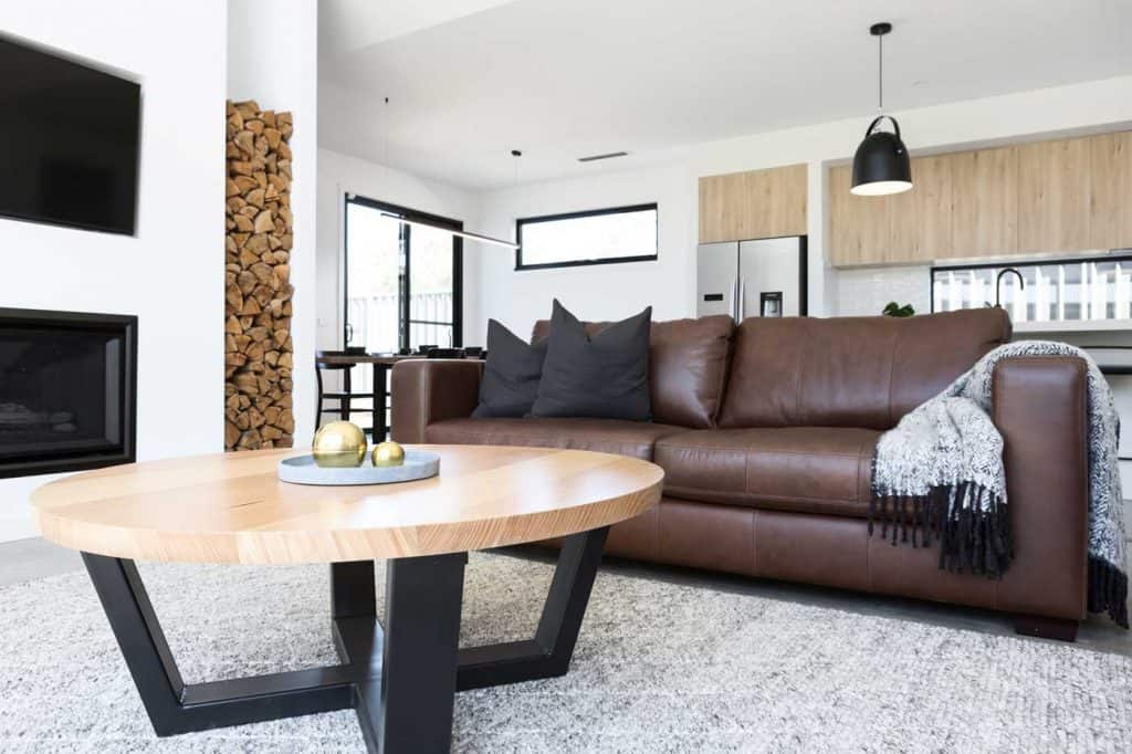 Luxury living room styled with dark brown leather sofa and oak coffee table