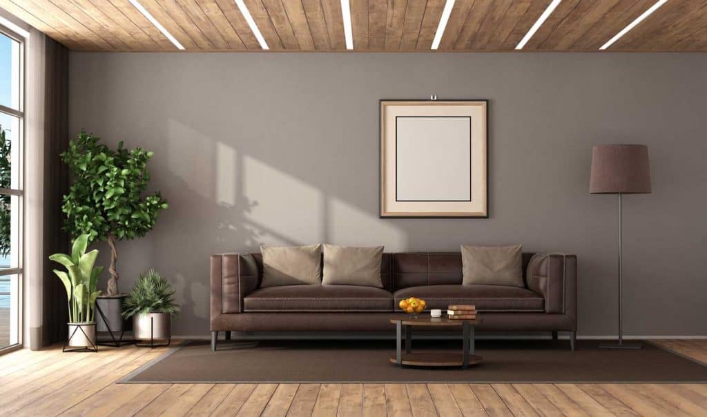 modern living room with dark brown leather sofa and LED light on wooden ceiling