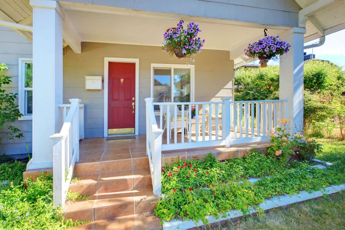 Beautiful front porch with hanging flowers and white fences at the balcony