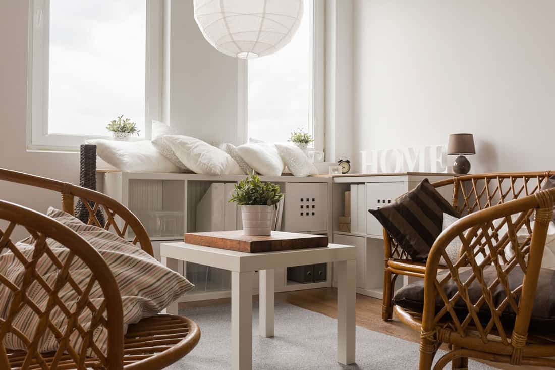 Brown skeletal-like-chairs with pillows on a white walled living room
