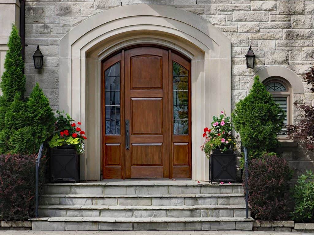 Elegant front door of stone house with flagstone steps