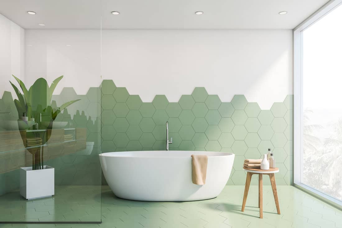 Interior of stylish bathroom with green hexagonal tile and white walls