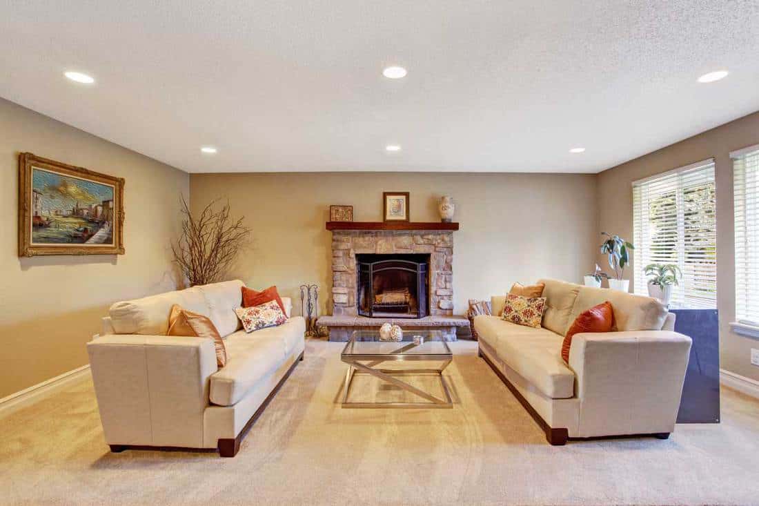 Living room interior in soft ivory with cozy fireplace