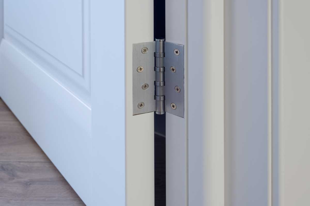 Metal chrome hinged hinges on a white interior door, Should Door Hinges Be Painted?