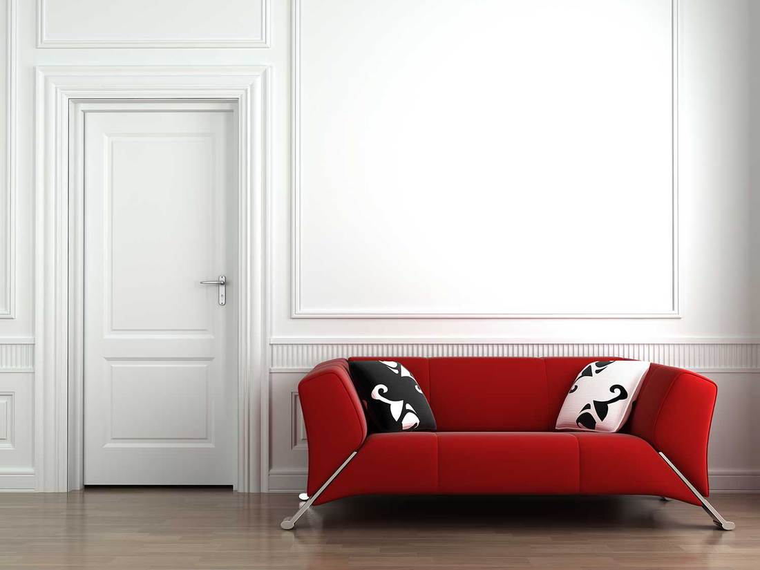 Red couch on white interior wall