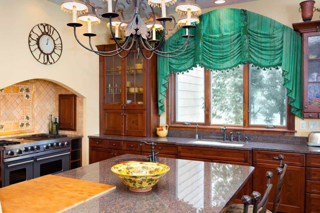 Stylish modern kitchen interior with chandelier and curtain