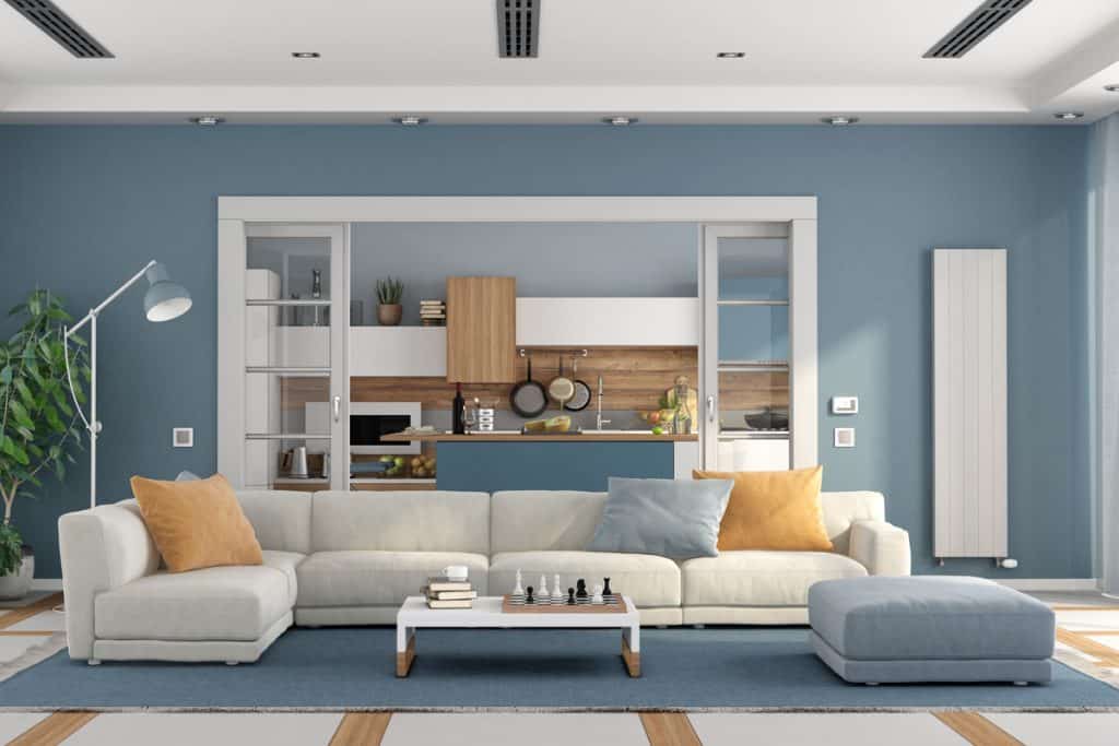 Een woonkamer met een blauw thema met een witte bank en een blauw vloerkleed
