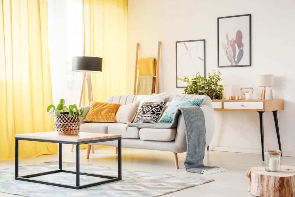 Un salon avec des rideaux au sol jaune moutarde avec une conception de salon d'approche minimaliste