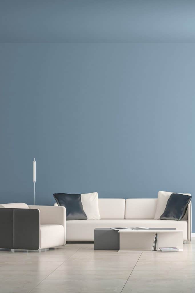 Un salon moderne avec un canapé blanc et des coussins gris sur le dessus