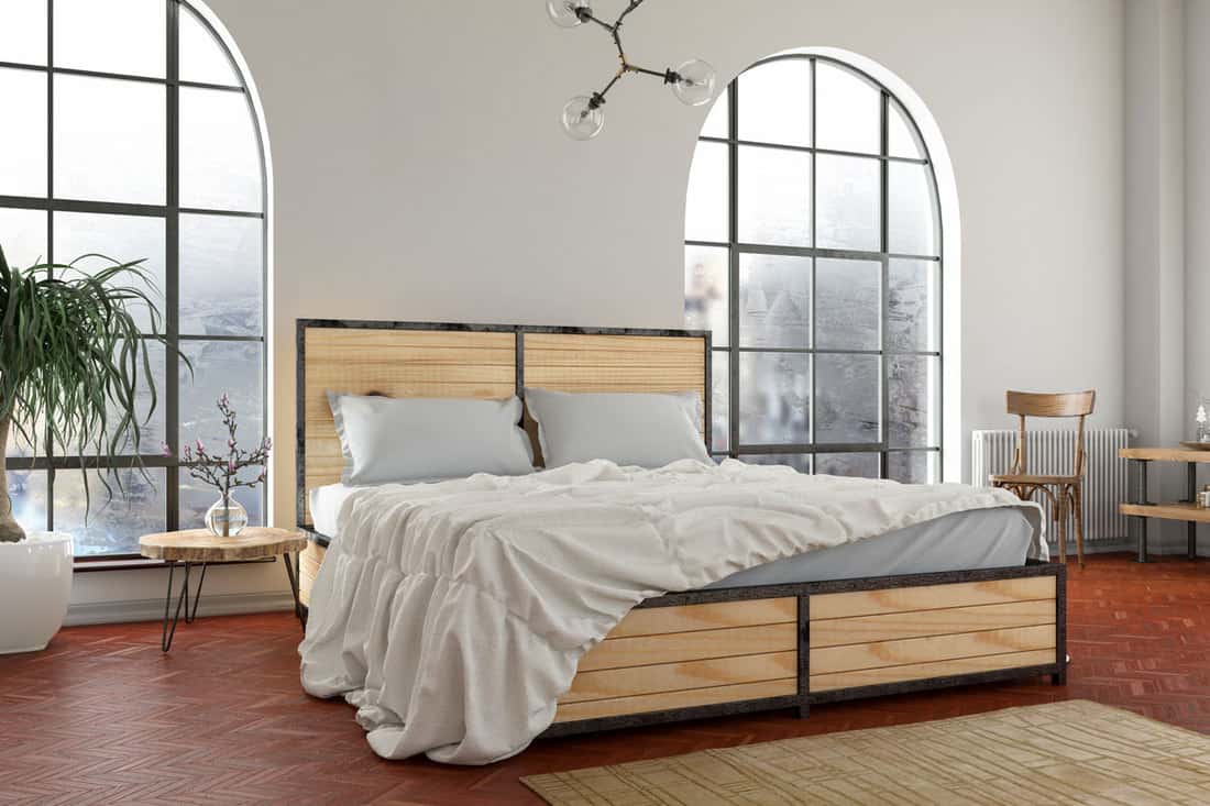 A white colored bedroom with a wooden bed and a white bedding set
