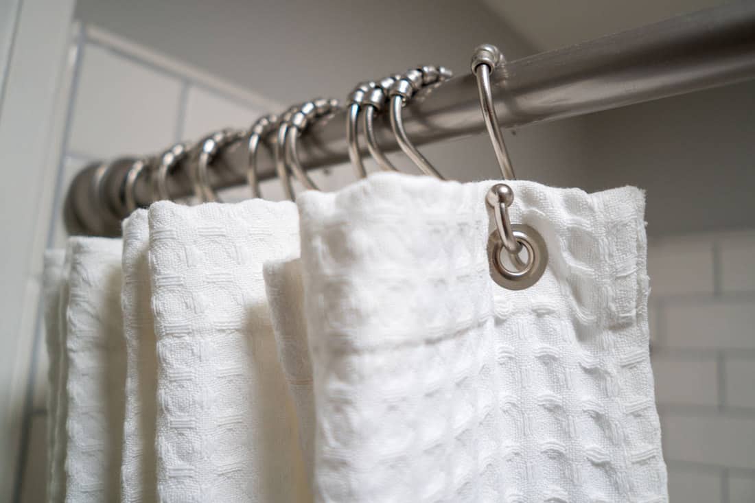 A white shower curtain with stainless steel curtain, How To Wash A Shower Curtain or Shower Curtain Liner