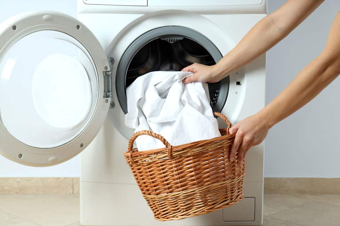 Doing laundry of white sheets in the washing machine