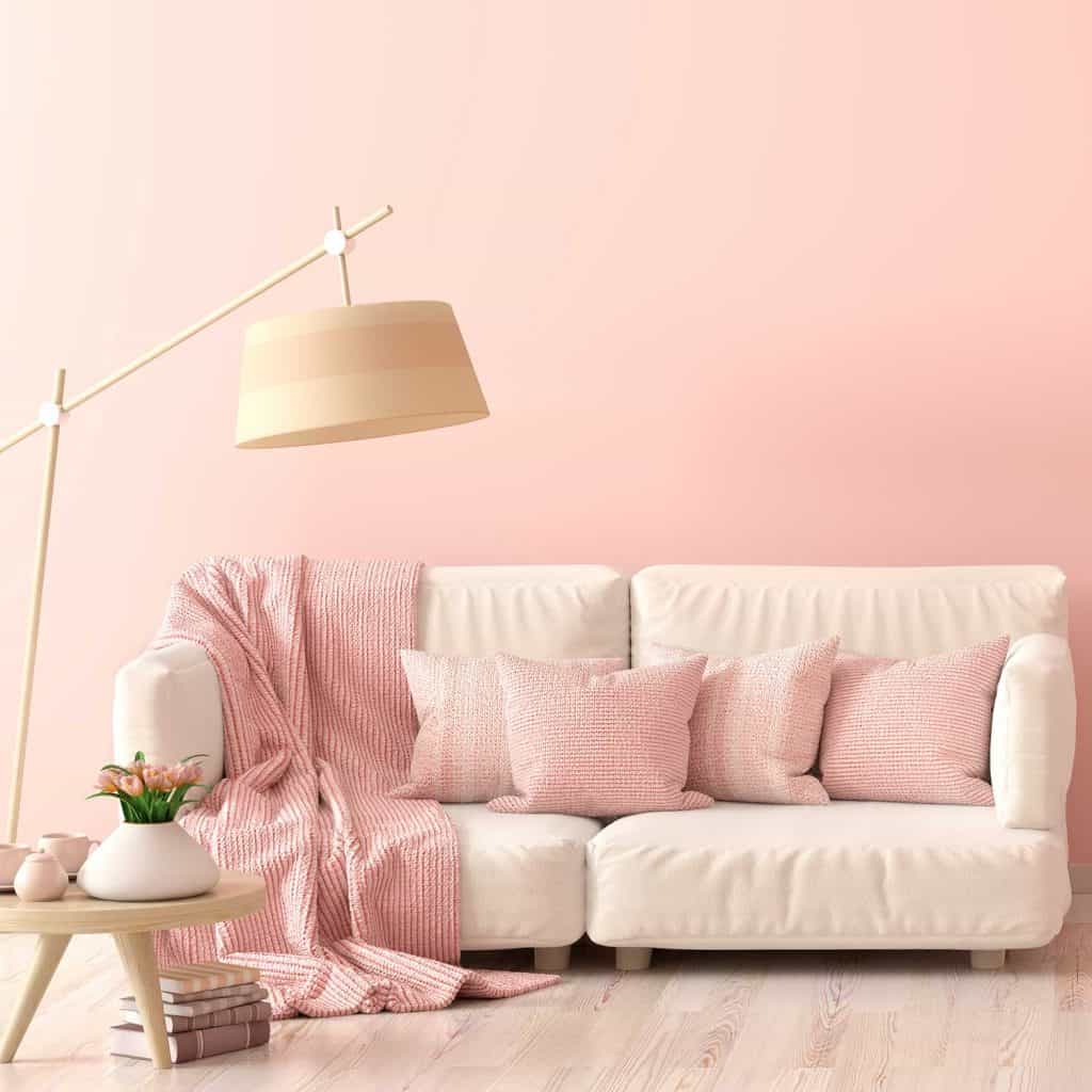 Interior design of modern living room with beige sofa, pink throw pillows, floor lamp and coffee table with tulips