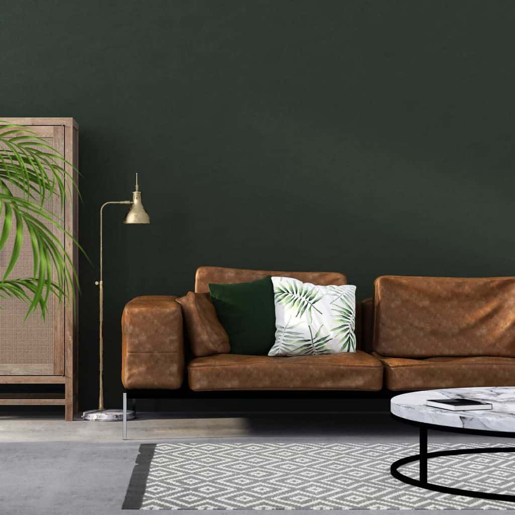 Interior of living room with brown leather sofa, floor lamp and standing cabinet against a green wall