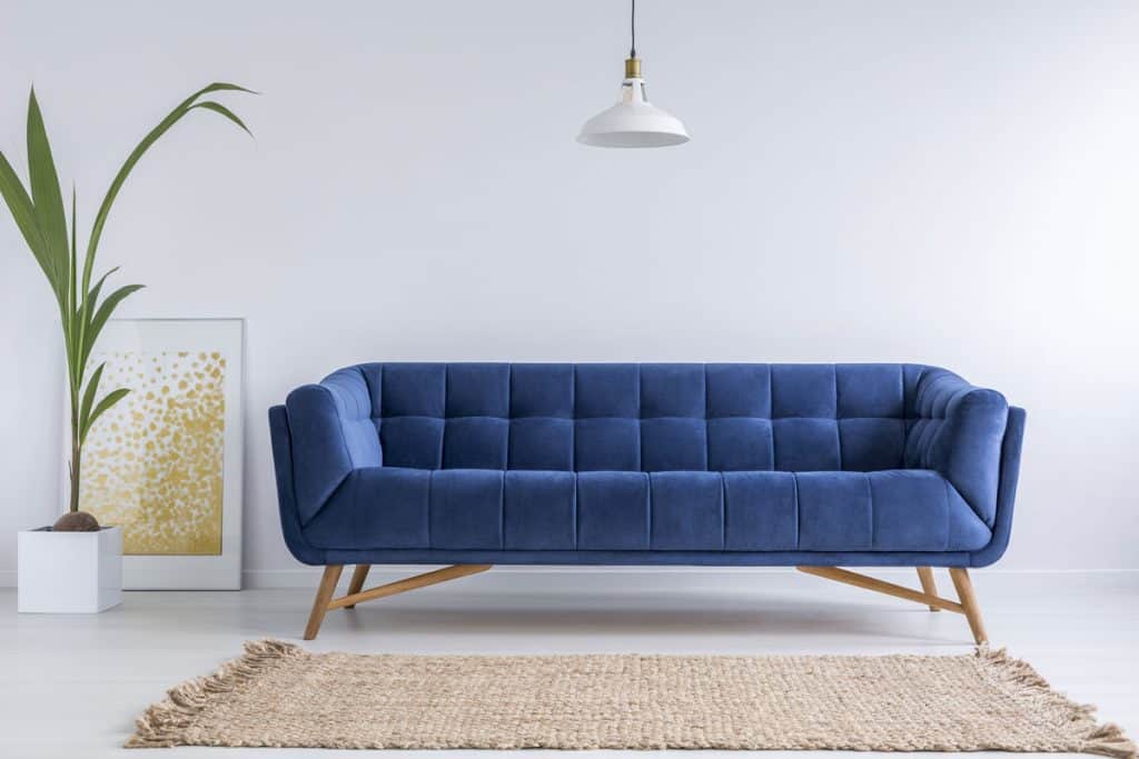 Long blue sleeper sofa inside a white living room