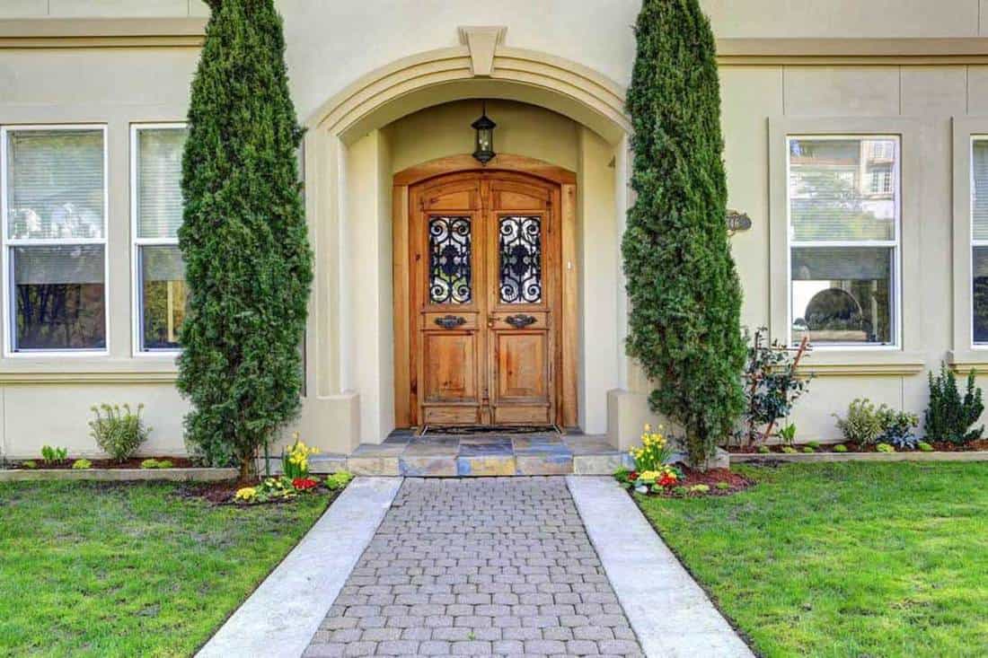 Luxury house entrance porch with walkway and arched wooden front door, Arched Front Door Ideas [Inc. 23 Pictures]