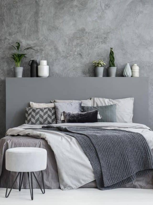 A gray modern bedroom with gray walls and indoor plants placed on the headboard