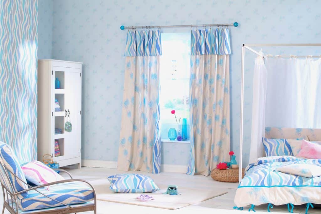 A blue themed bedroom with a white colored cabinet