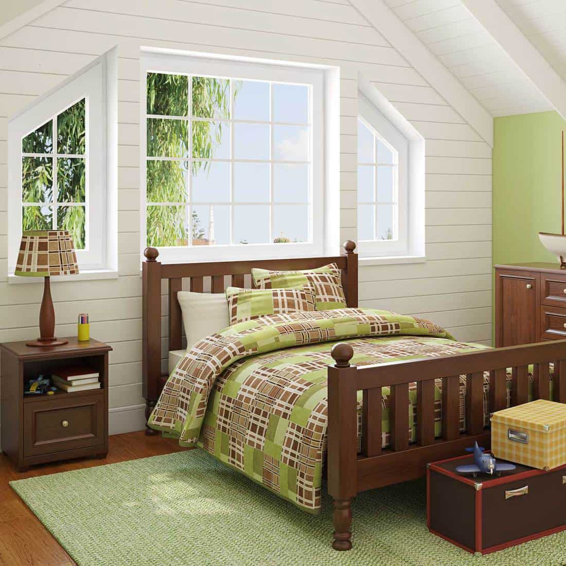 Green themed boys bedroom with wooden furniture and bed beside the window