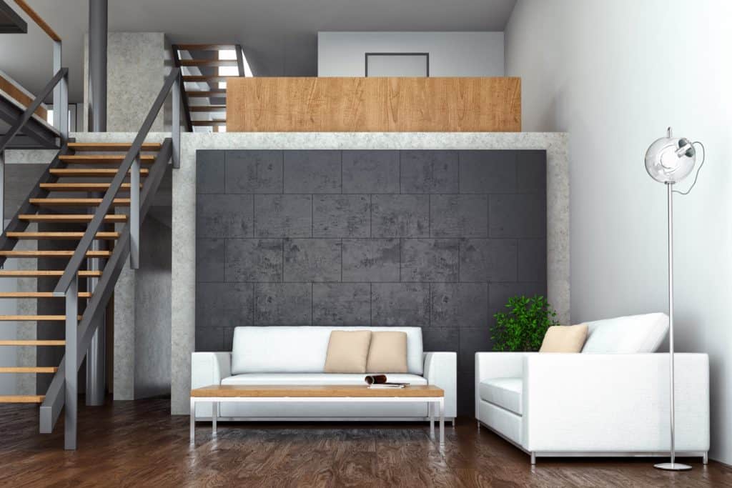 A cool contemporary inspired two storey apartment living room with a decorative gray wall and dark wooden paneled flooring