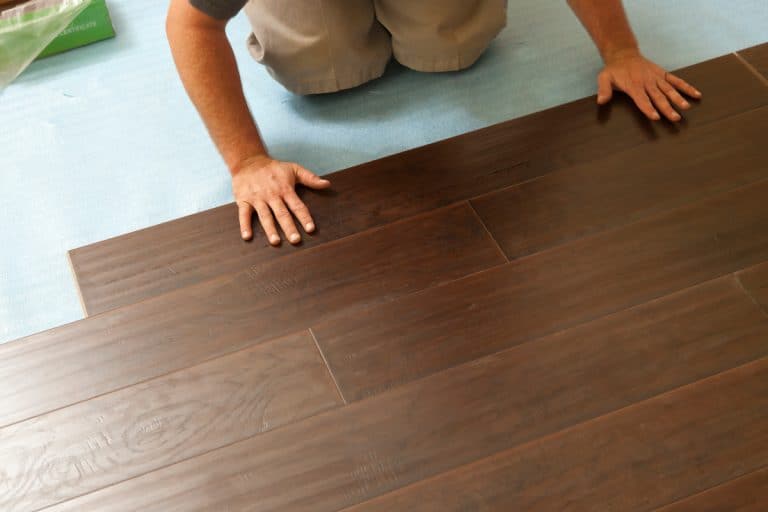 A man installing laminate flooring on the newly finished floor, Is Laminate Flooring Good For An Entryway?