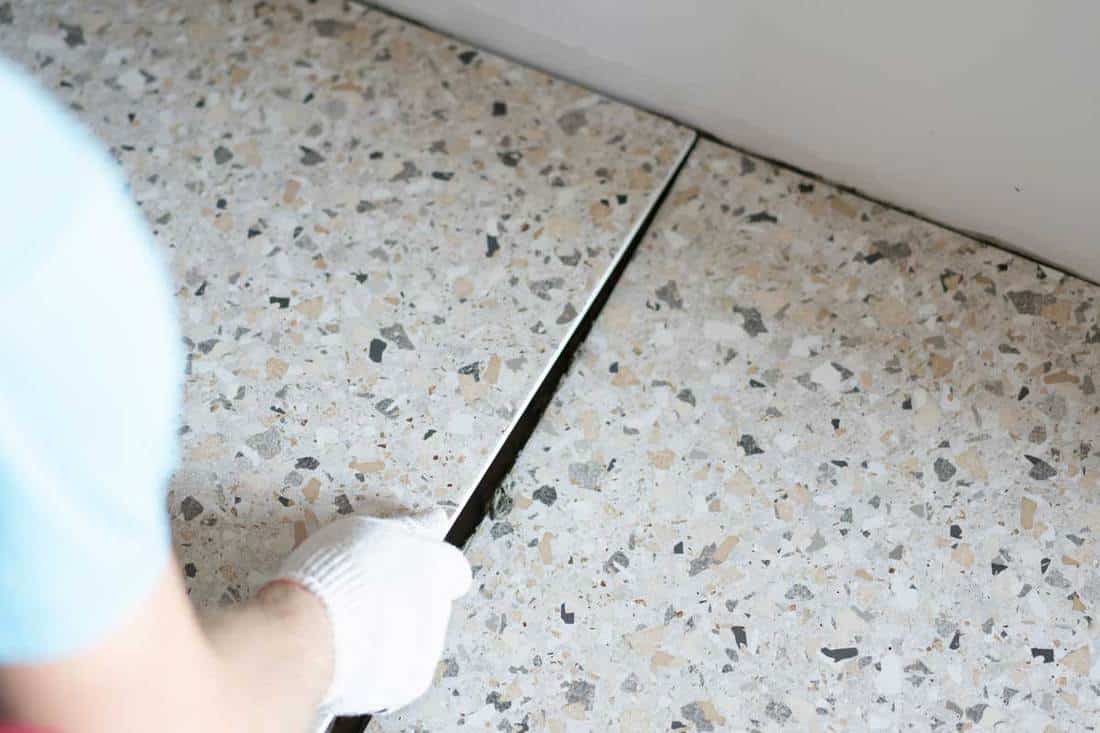 A professional lay porcelain tiles on the floor in the bathroom, How To Drill Through a Porcelain Tile in 5 Easy Steps