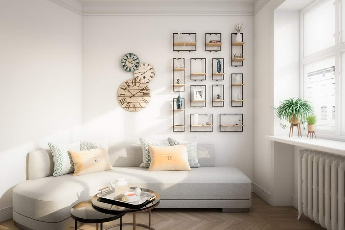 A Scandinavian themed living room with wall clock hanging on the wall and picture frames arranged neatly forming a rectangle, Where To Put The Wall Clock In Your Living Room?