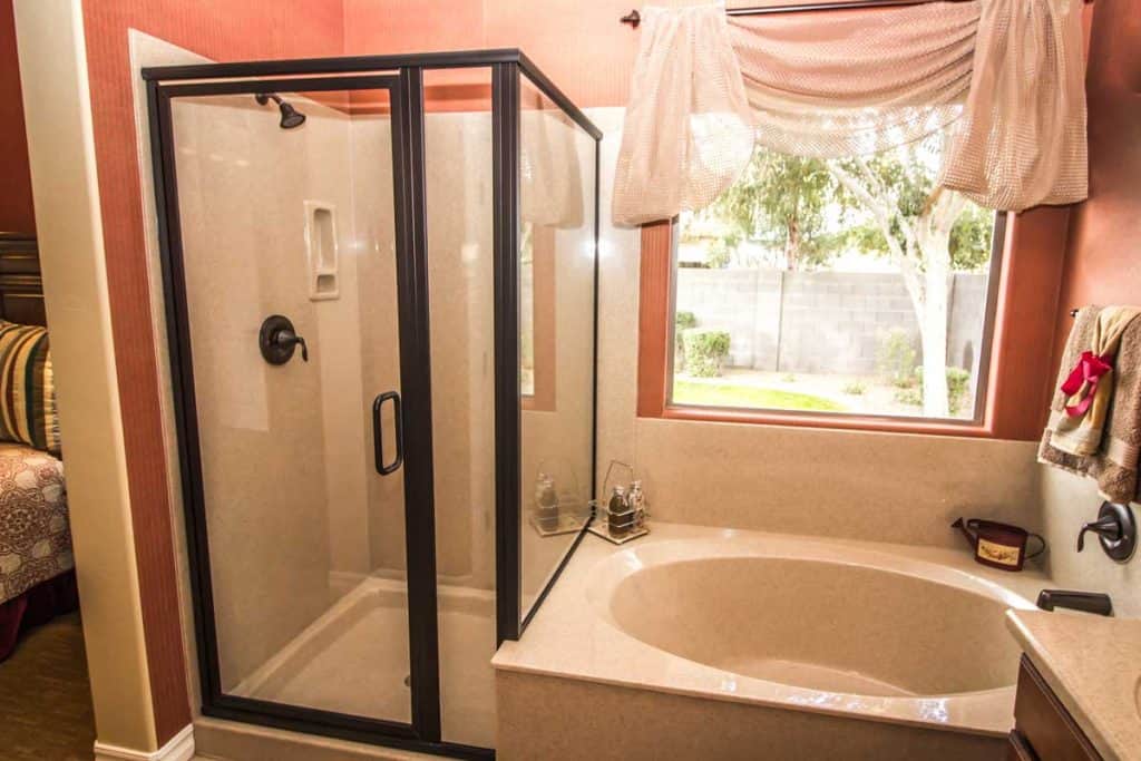 Salle de bain corail avec porte de douche et baignoire en verre transparent