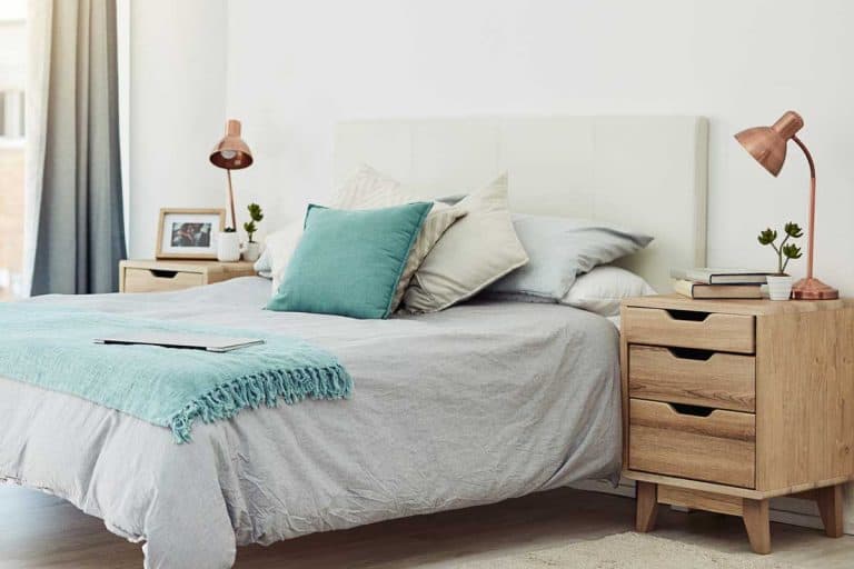 Cropped shot of an empty and neatly arranged bedroom at home during the day with nightstands, What Do You Put In Nightstands? [9 Nightstand Essentials]