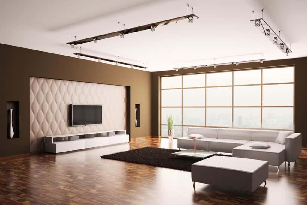 Huge windows inspired with a brown colored wall all over the living room and mixed with wooden patterned tiles