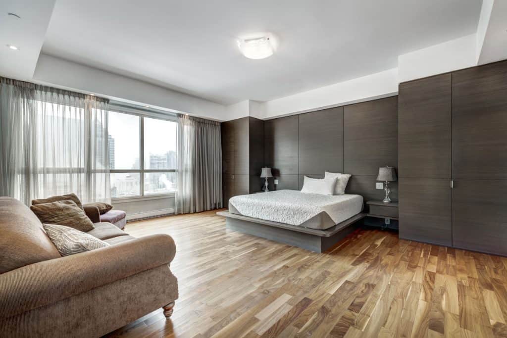 Living room with modern interior and laminated flooring with a king-sized bed