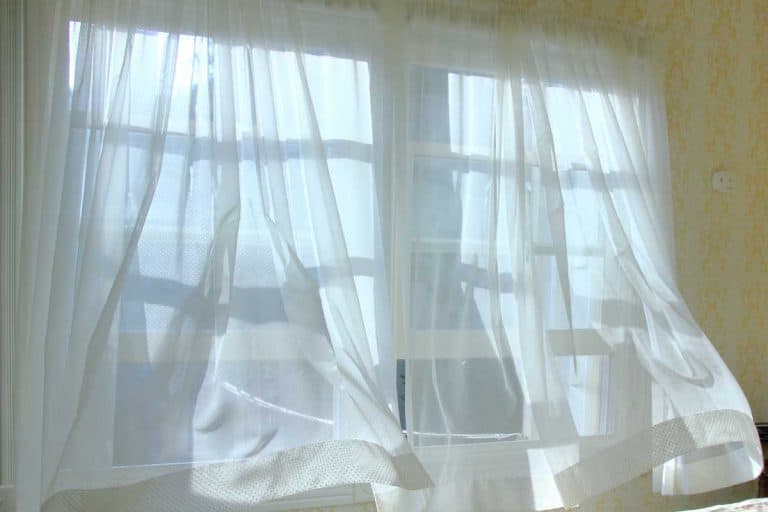 Morning bringing a cool ocean breeze through bedroom window, Do Curtains Absorb Sound? Here's what you need to know