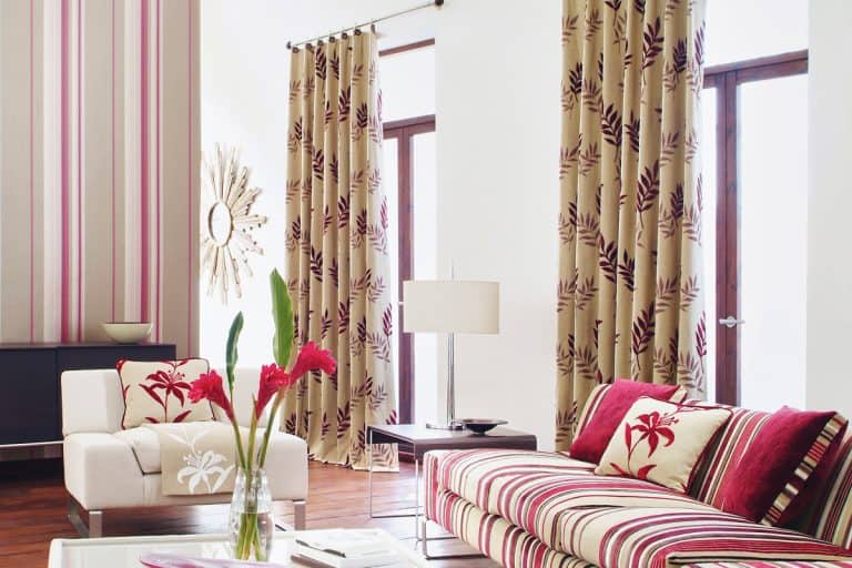 Living room with brown floral curtains matched with pink and white sofa, Should Your Curtains Face In Or Out?