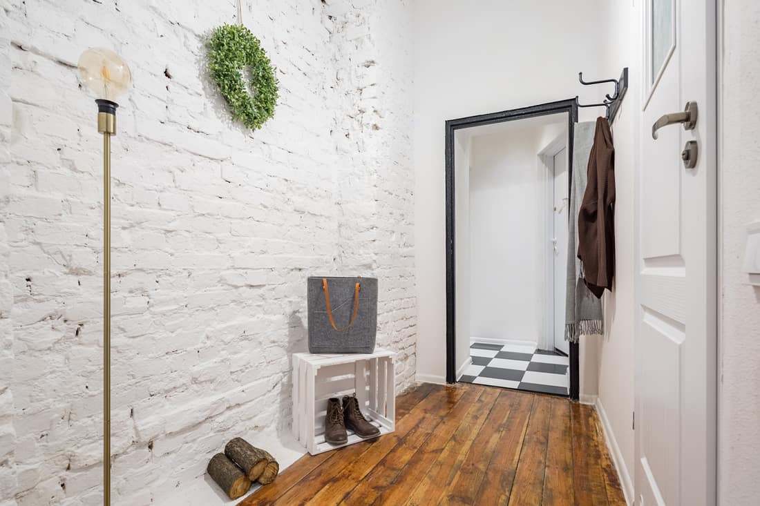 A small entryway with white colored brick vinyl laminated wooden flooring, What Should You Put In A Small Entryway? [7 Crucial Items]