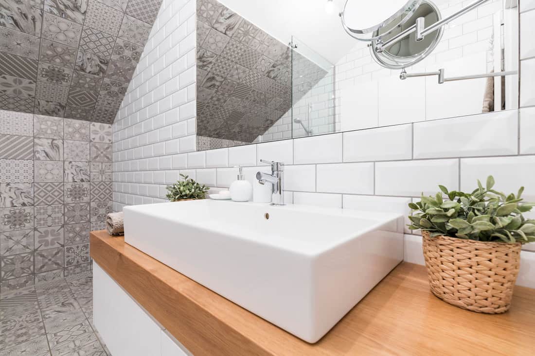Eigentijdse badkamerhoek met decoratieve tegels en een rechthoekige keramische wastafel