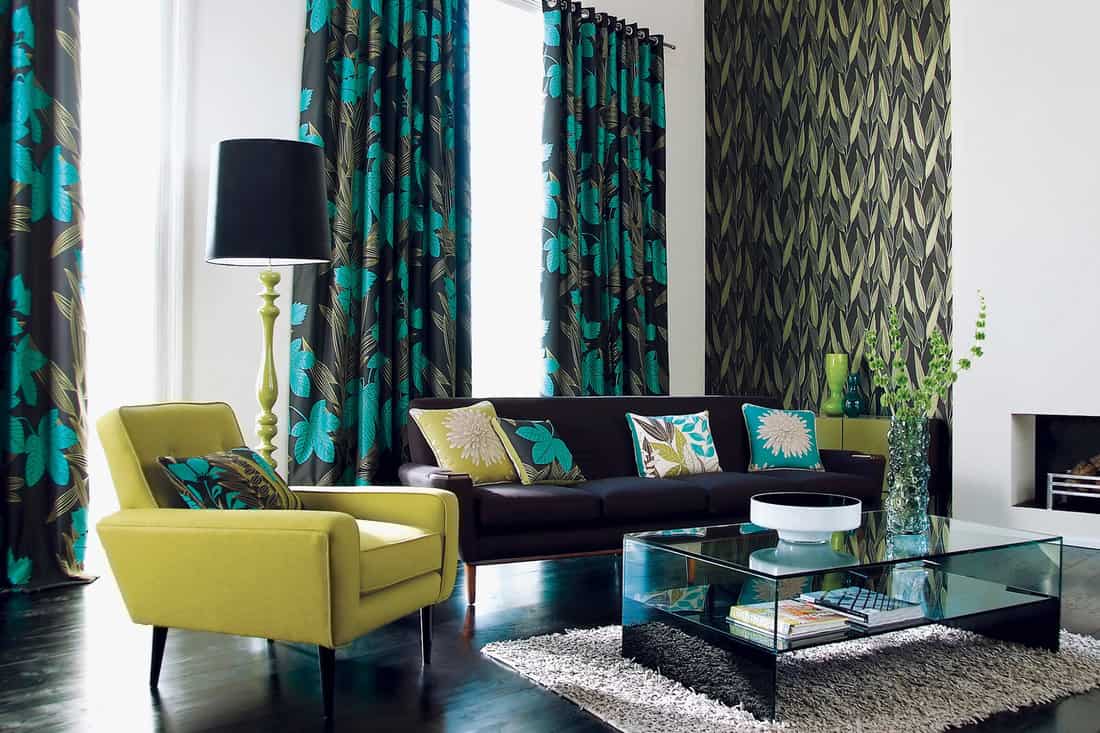 Interior of stylish sofa, chair, curtains and ornaments in a modern livingroom