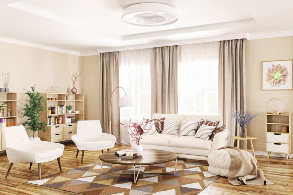 Intérieur moderne du salon avec canapé blanc, fauteuils, table basse et rideaux marron