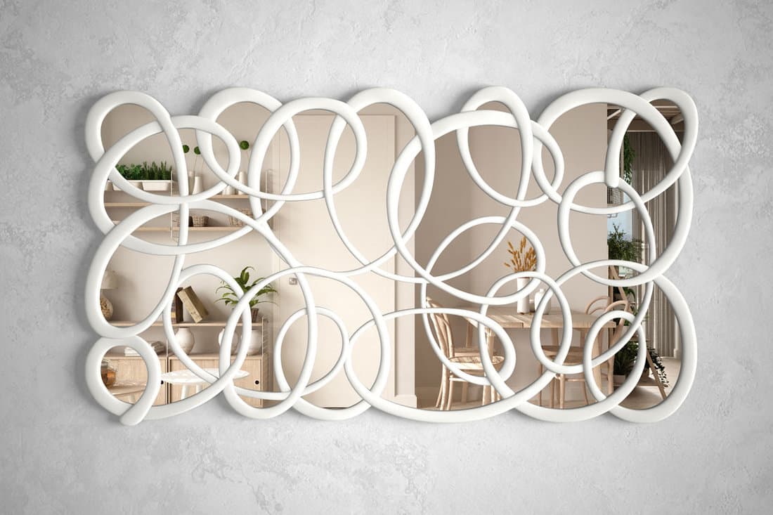 Modern twisted shape mirror hanging on the wall reflecting interior design scene, cosy sustainable dining and living room