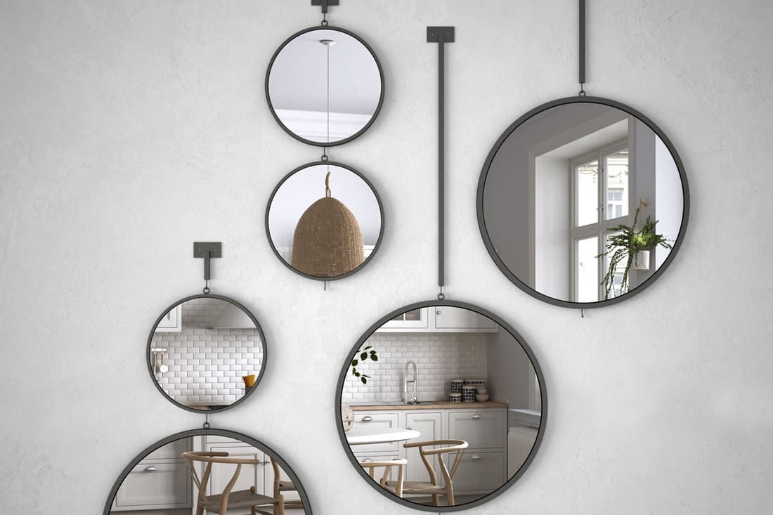 Round mirrors hanging on the wall reflecting interior design scene