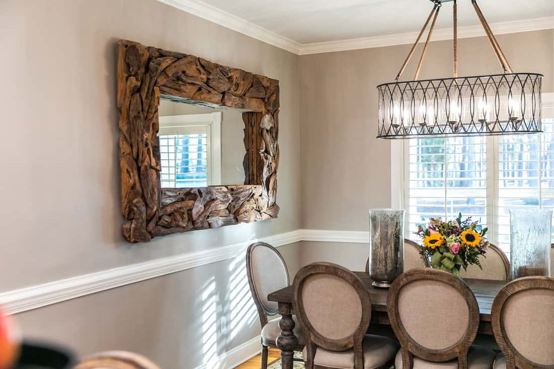 Small updated dining room with large driftwood mirror