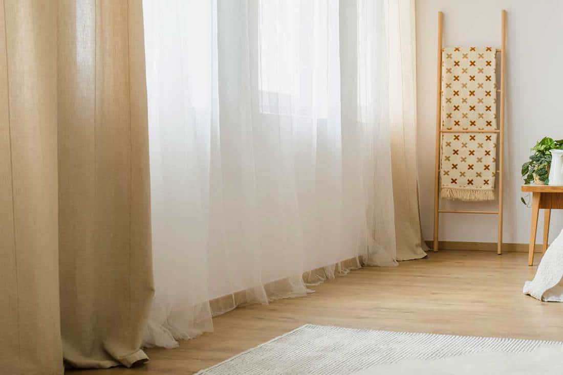 White and brown curtains in a hygge style bedroom interior, How to Embellish Plain Curtains [4 Awesome Suggestions]